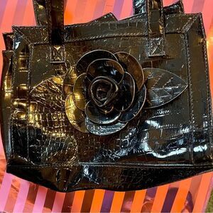 Black alligator-look vinyl purse w/ 3-D flowe design.  Magnetic closure snap